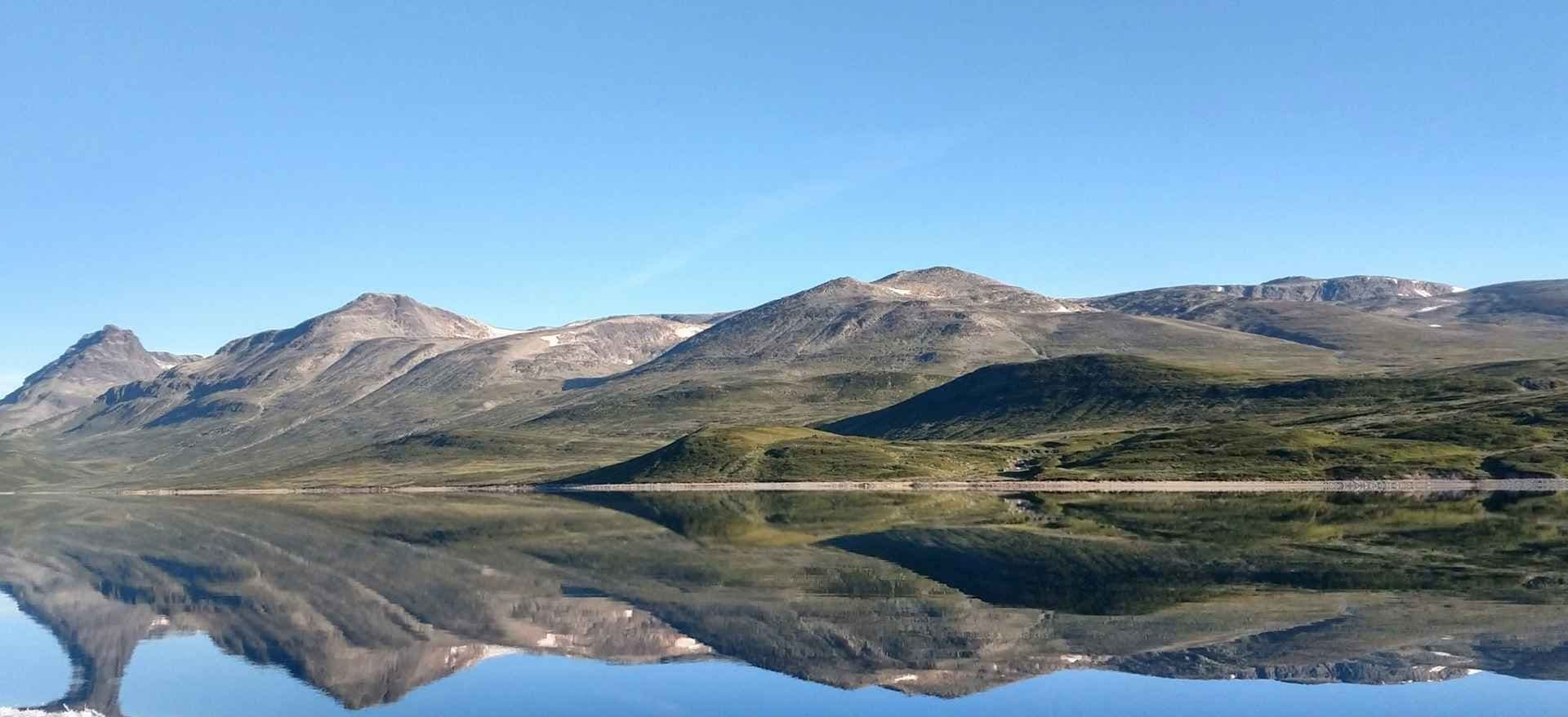 Vang i Valdres speiler seg i vannet. Foto. 